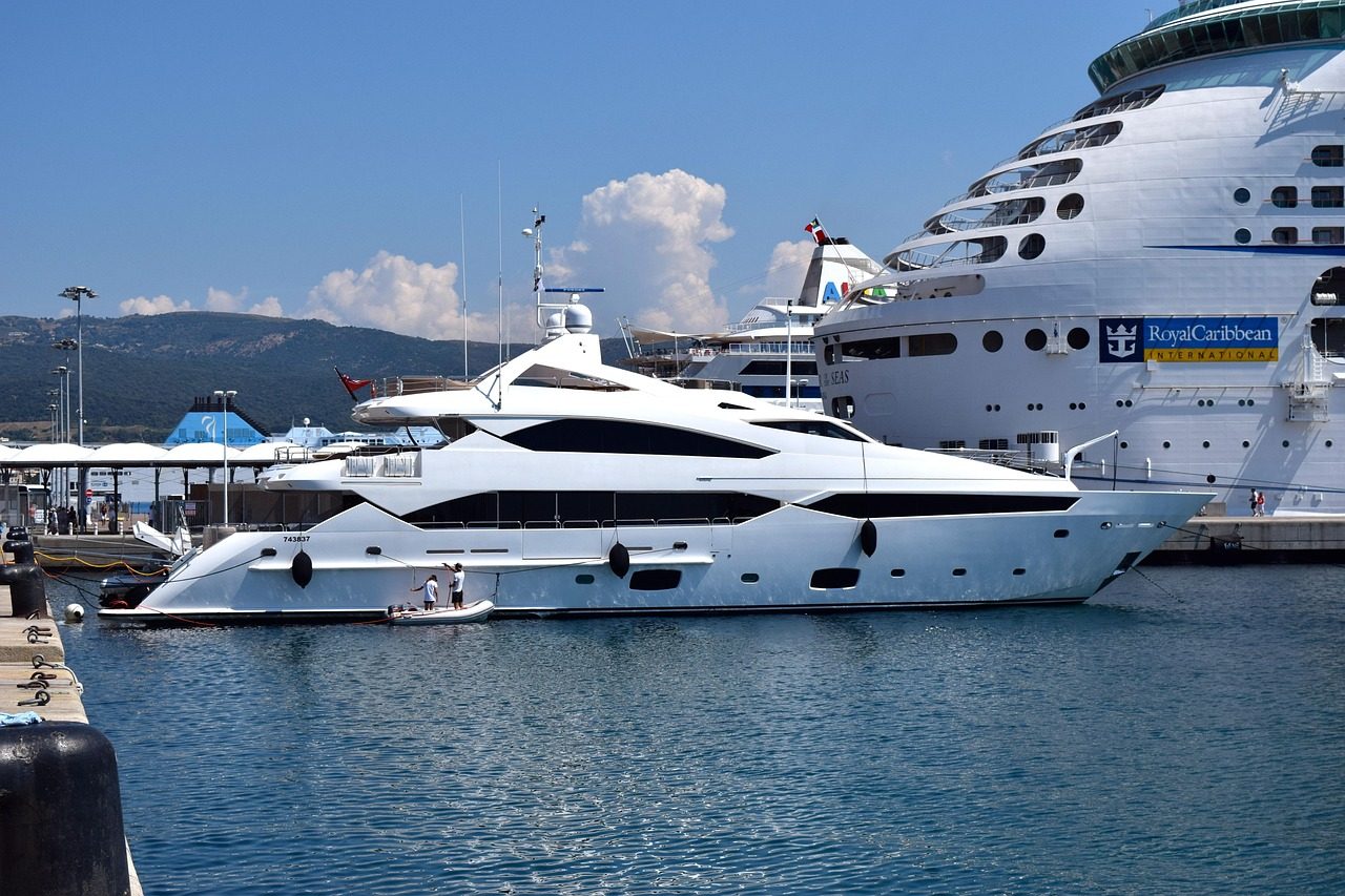 Motor yacht docked next to a cruise ship