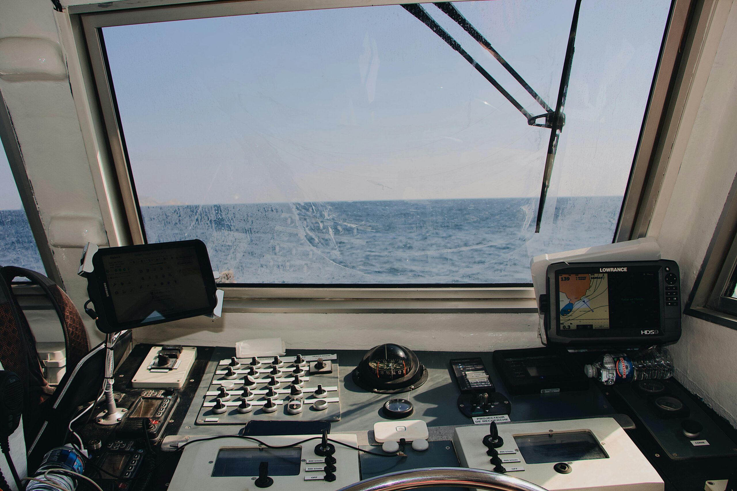 View from a boat cockpit featuring navigation equipment, overlooking the vast ocean