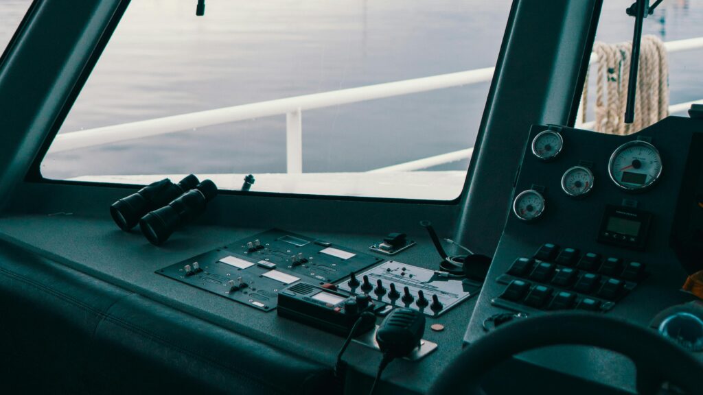 Interior of a boat cockpit showcasing controls and a pair of binoculars.